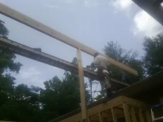 Carpenter setting a ridge beam over a new addition frame — Ice Dam Removal by Roofing Brothers in Batesburg