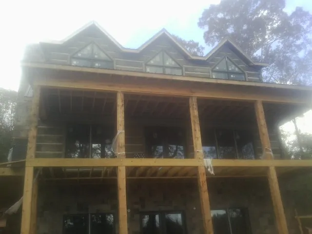 Dormers and porch framing on a large log home under construction — Roof Coating work by our crew in Batesburg
