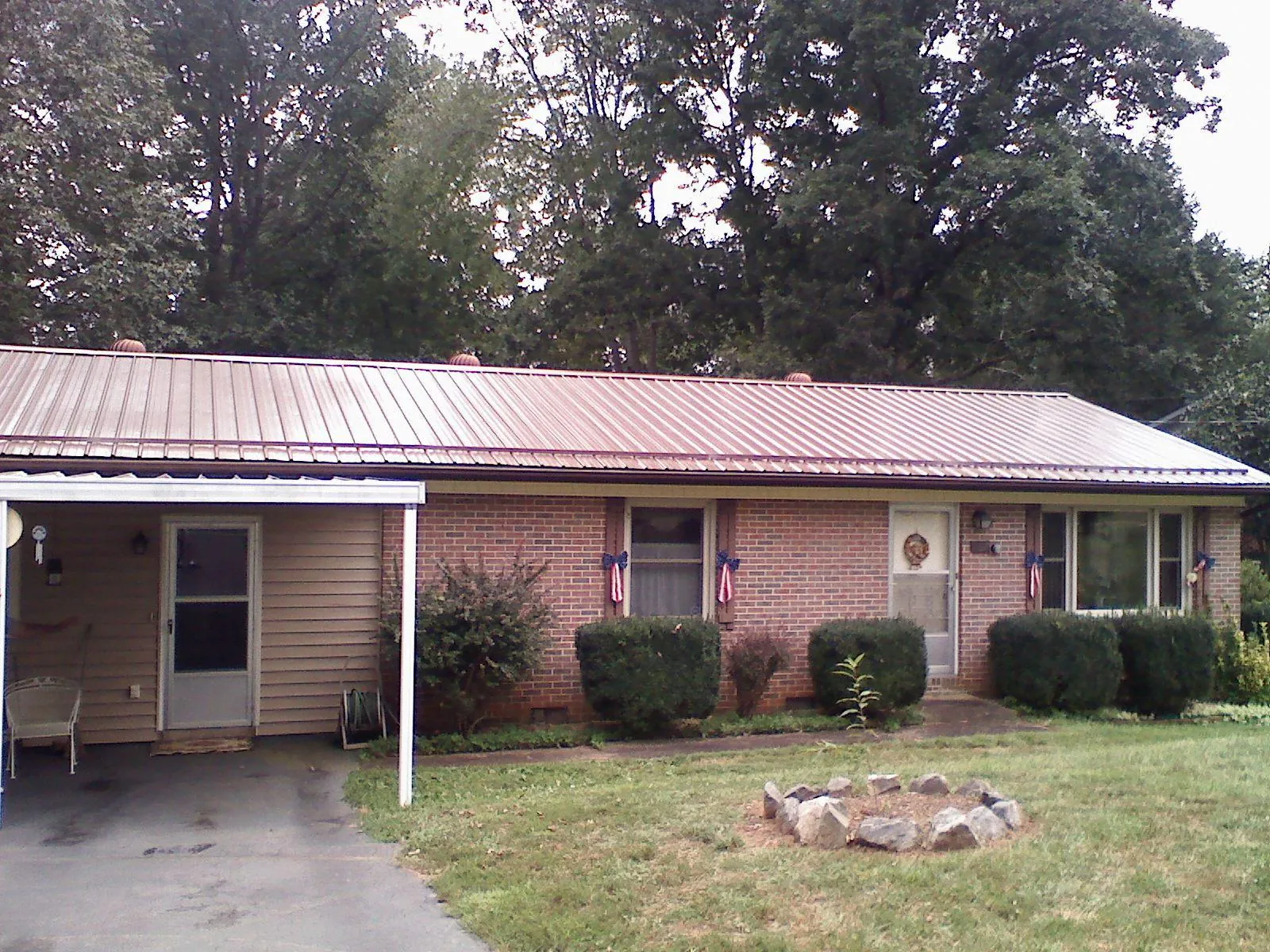 Bronze metal roof and carport on a brick ranch home — Roof Repair work by our crew in Batesburg